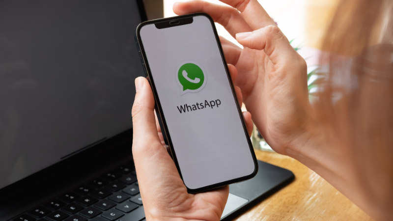 Smartphone com ícone do WhatsApp envolvido em diálogo político, representando o uso do aplicativo como ferramenta política no blog.