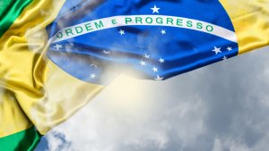 Representação de uma reunião de presidentes brasileiros longevos em torno de uma mesa de madeira com a bandeira do Brasil ao fundo.
